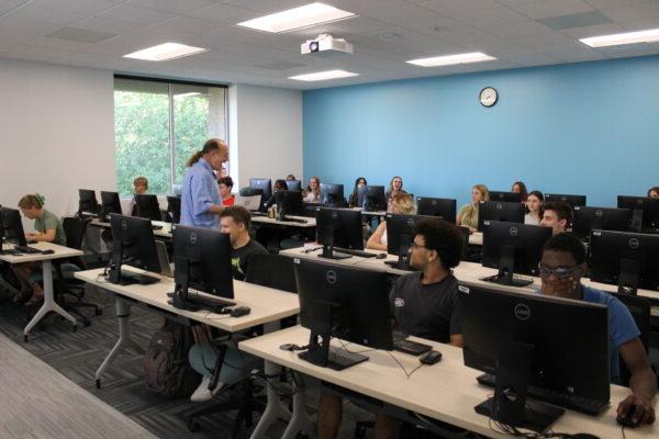 A group of people in a room with computers